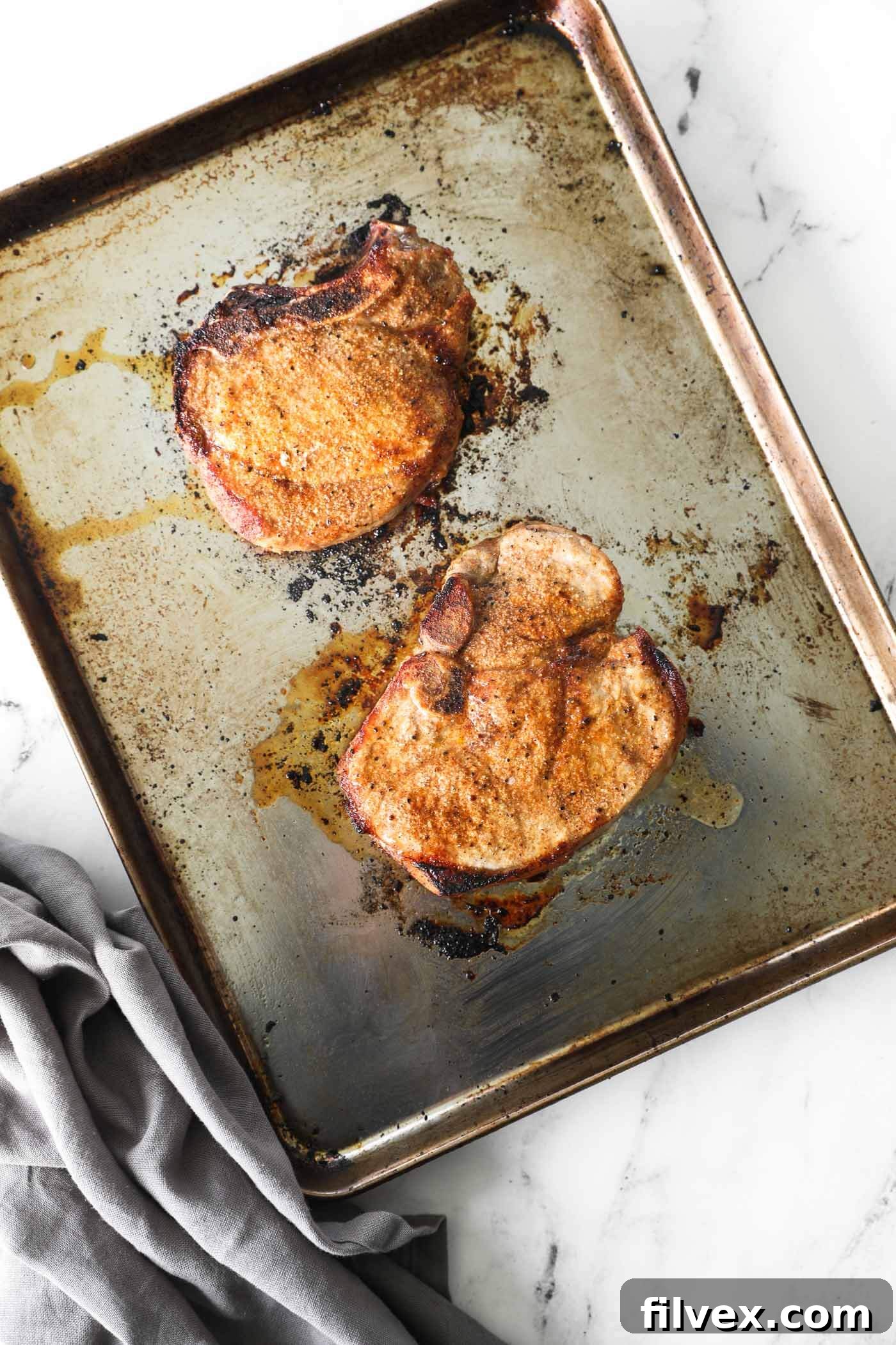 Pork chops broiling in an oven, showcasing a beautiful, caramelized golden-brown crust forming under the intense heat.