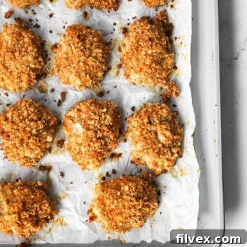 Cooked golden brown homemade ground chicken nuggets on a sheet pan