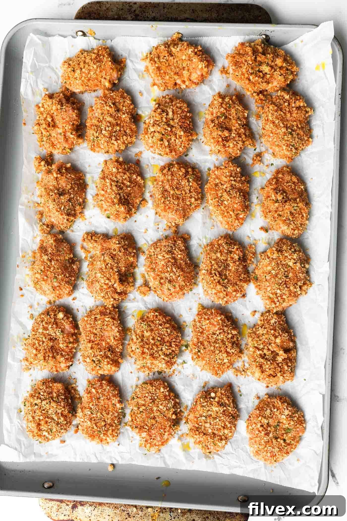 Repeating the breading process for all remaining chicken nugget pieces