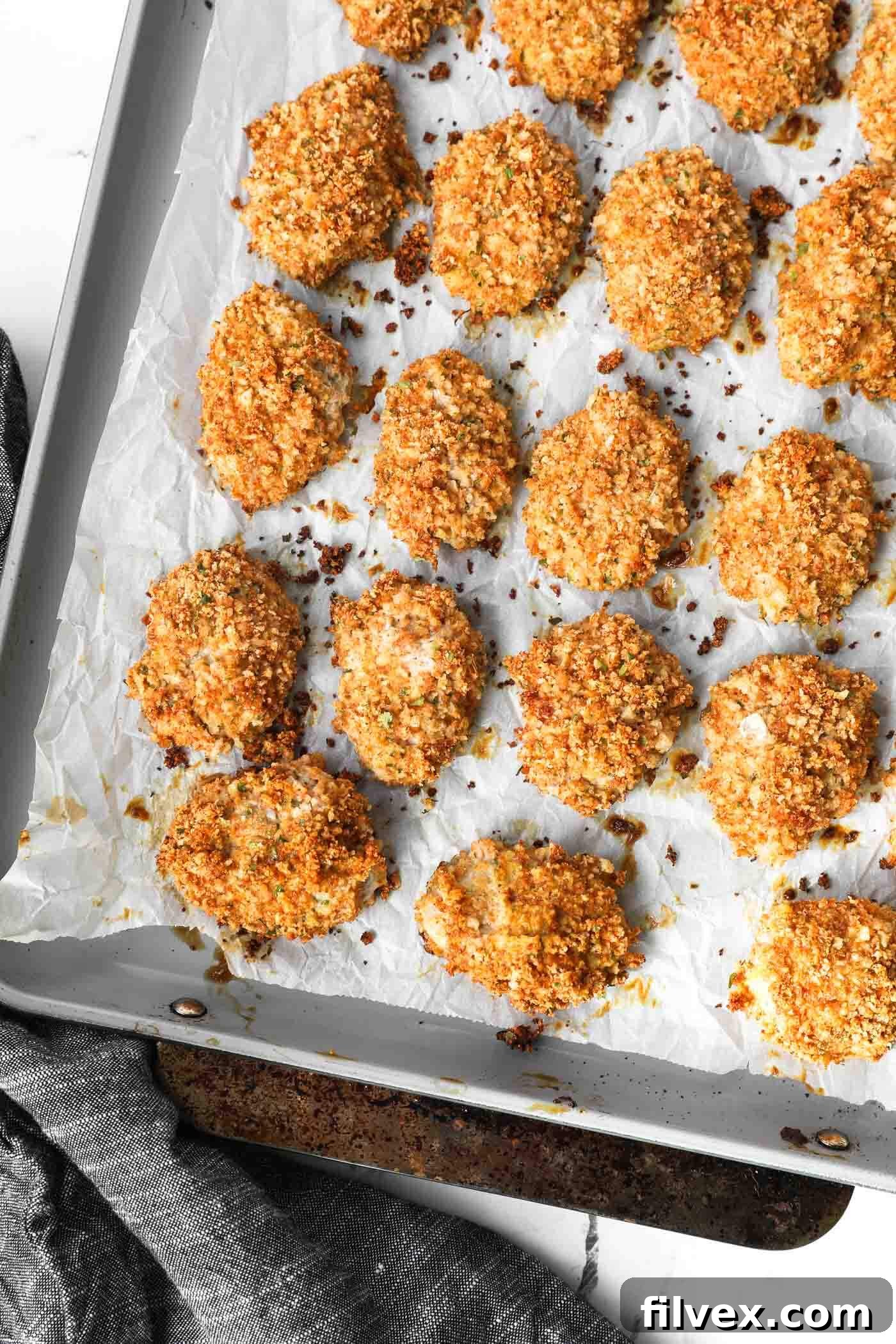 Baked crispy ground chicken nuggets on a sheet pan
