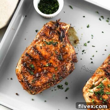 Overhead shot of grilled pork chops on a sheet pan, ready to be served, showcasing their perfect sear and juiciness.