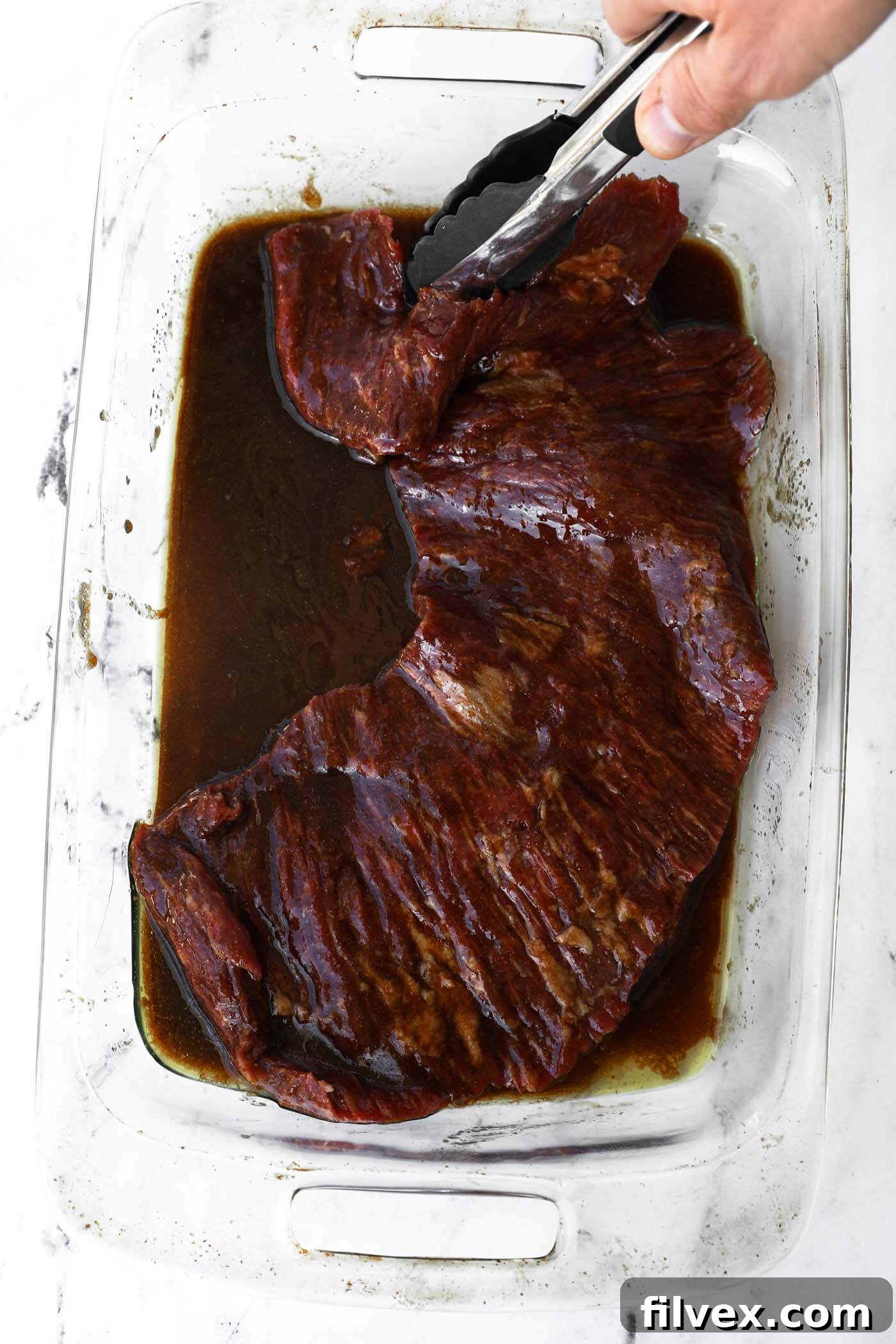 Perfectly grilled steak, glistening with balsamic glaze, served on a plate.