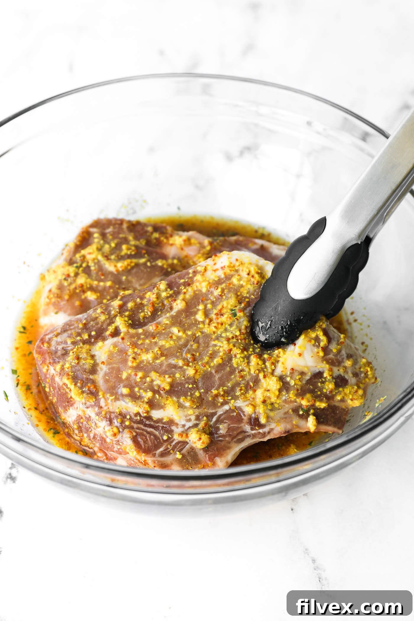 Tossing chicken in honey mustard marinade to ensure even coating.