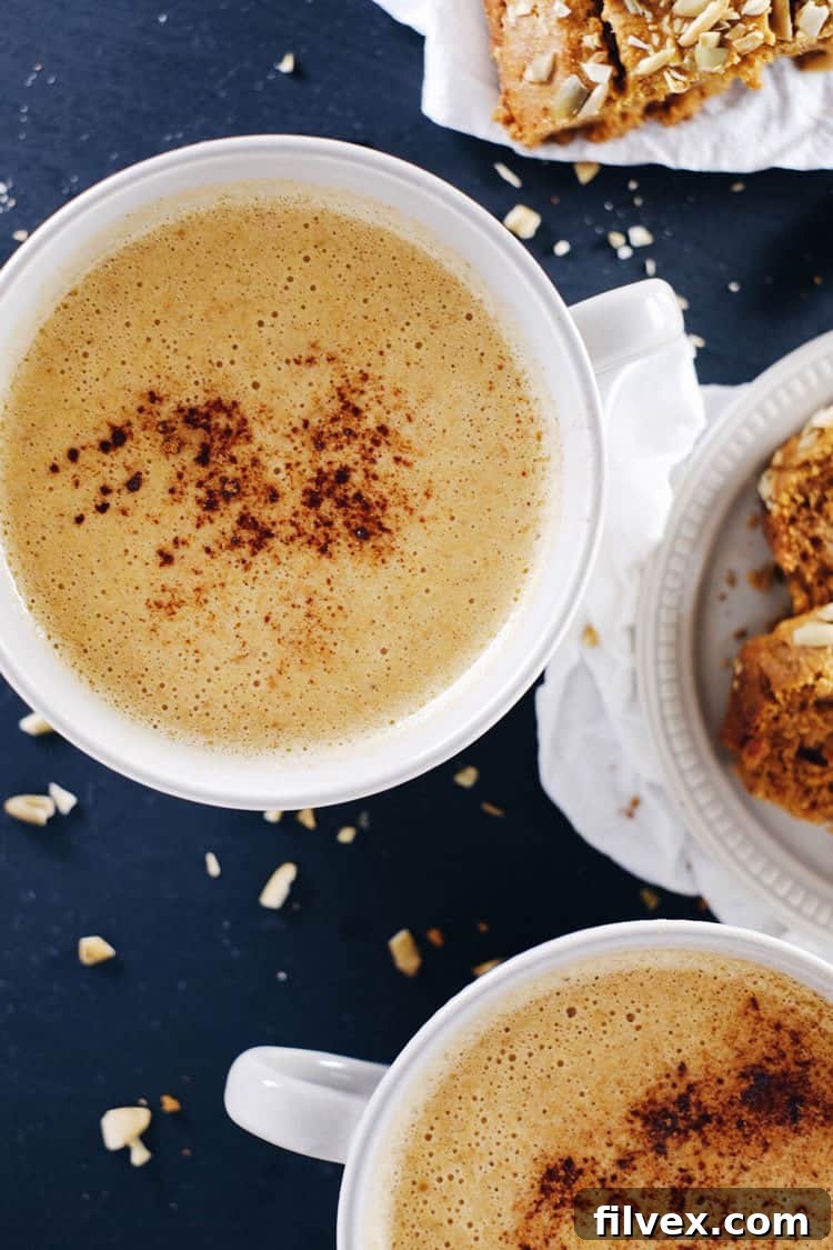 Preparing a frothy, dairy-free pumpkin chai latte in a blender for a smooth and creamy texture.