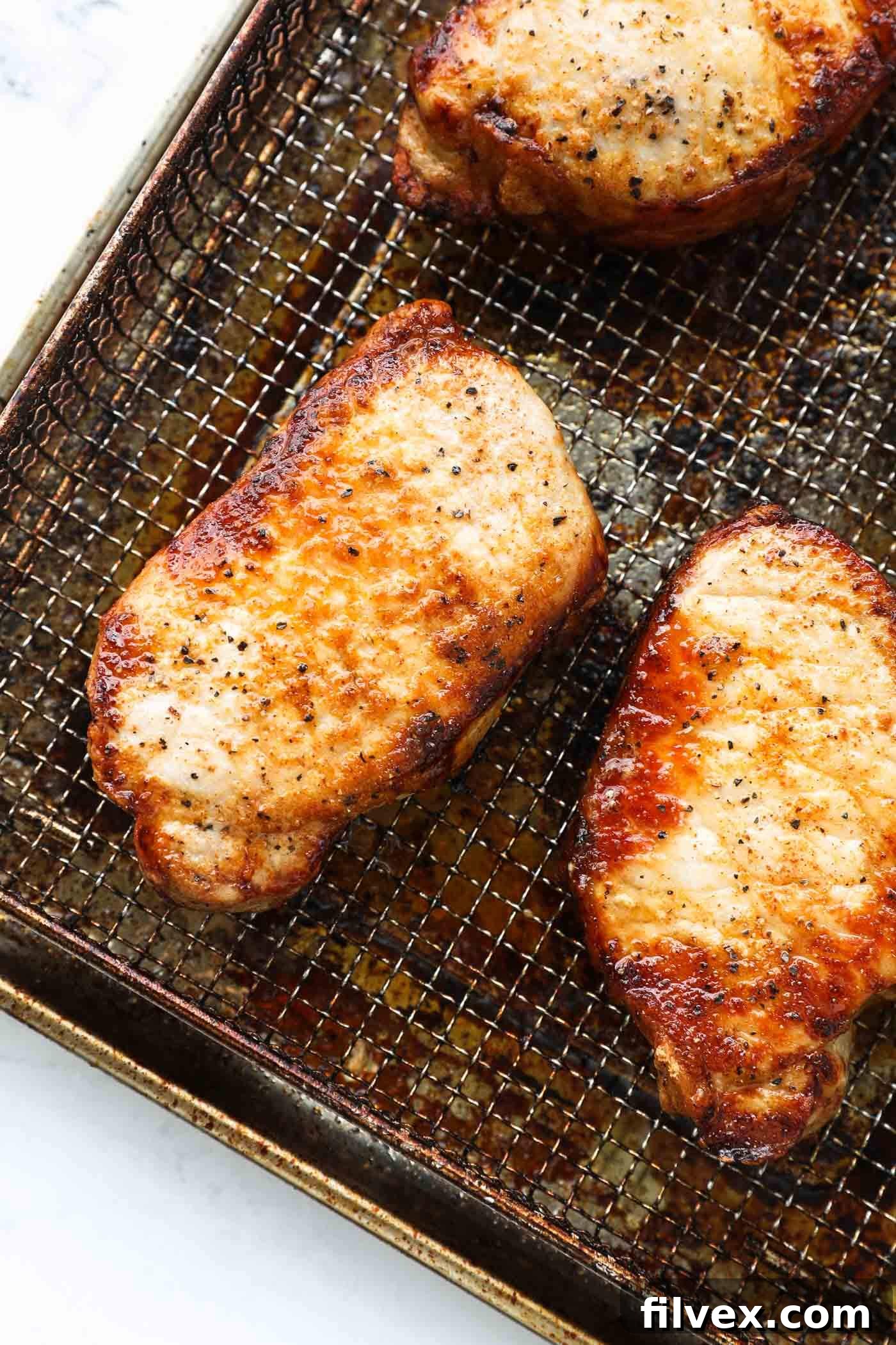 Cooked air fryer pork chops being checked with an instant-read thermometer