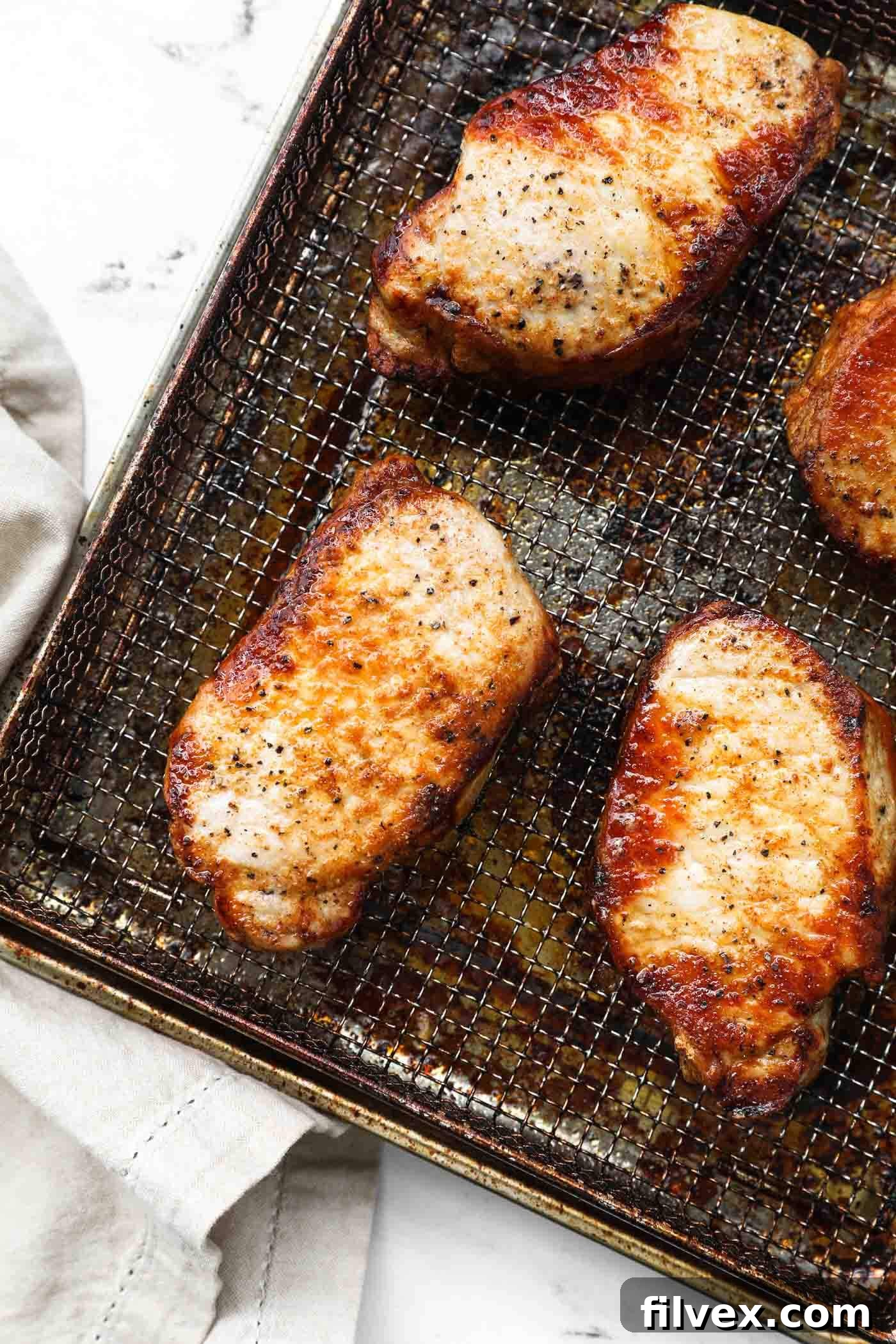 Plated air fryer frozen pork chops served with a side dish, looking moist and delicious