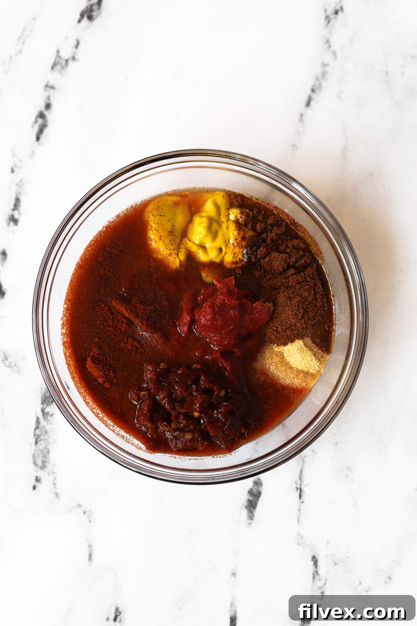 All ingredients for chipotle BBQ sauce placed in a mixing bowl before whisking.