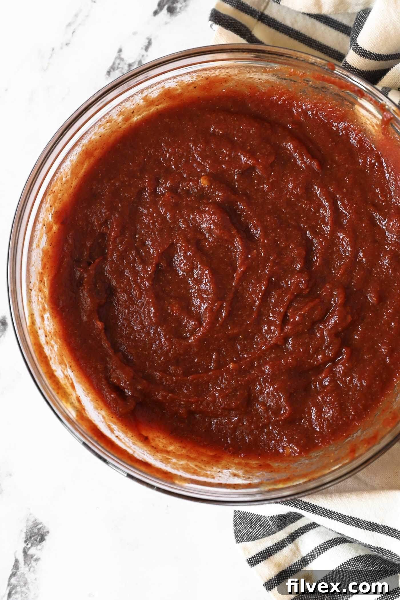 A bowl of homemade chipotle BBQ sauce with a spoon, ready to be served.