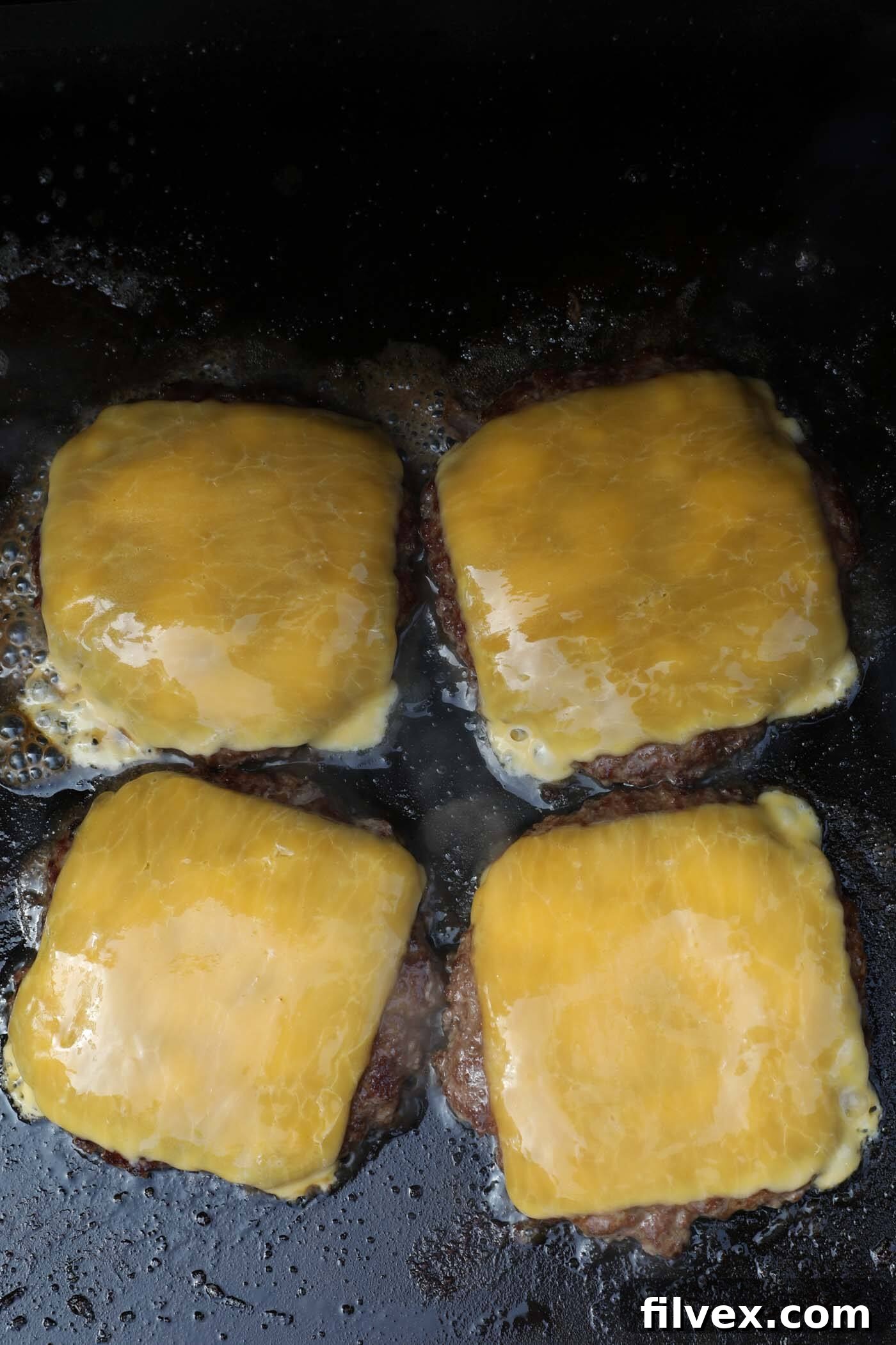 Removing finished smash burgers from the griddle