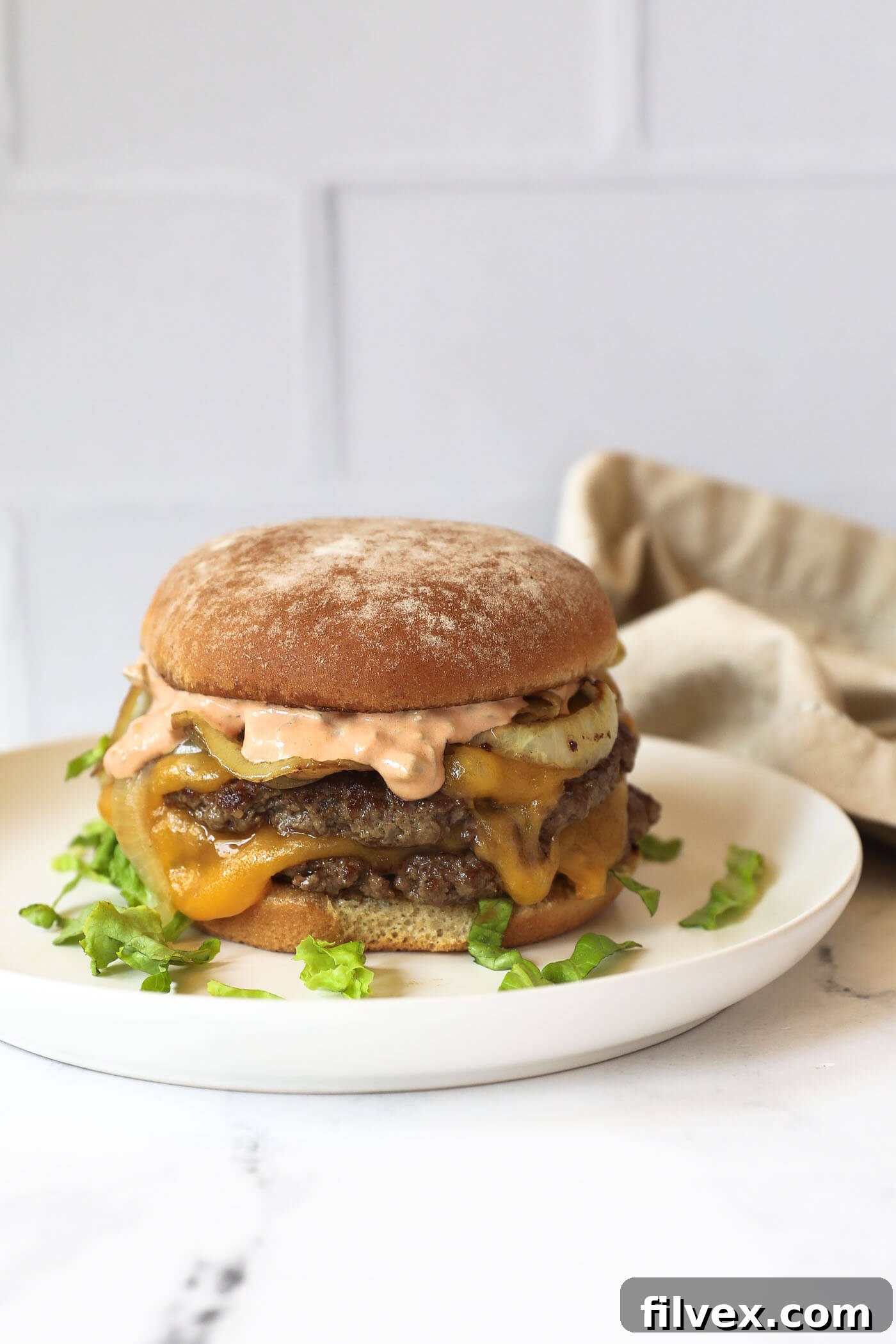 Assembling a smash burger with special sauce and toppings
