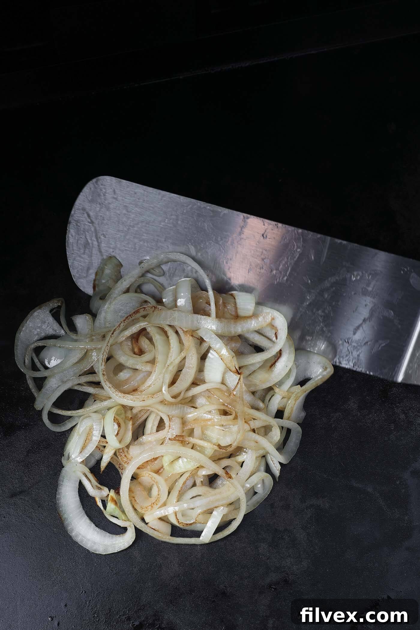 Cooking sliced onions on a hot griddle