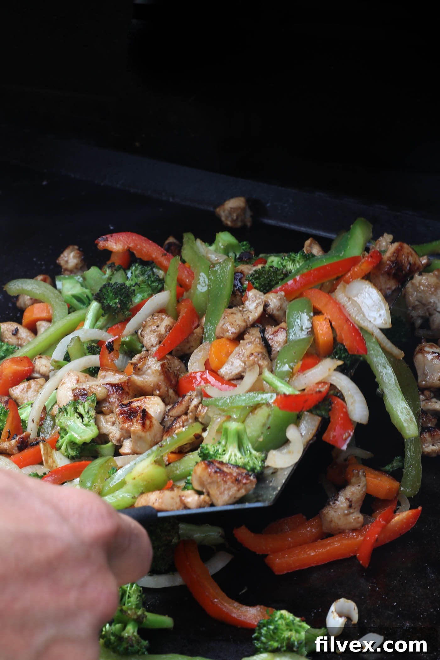 Cooked chicken and tender-crisp vegetables are combined on the Blackstone griddle.