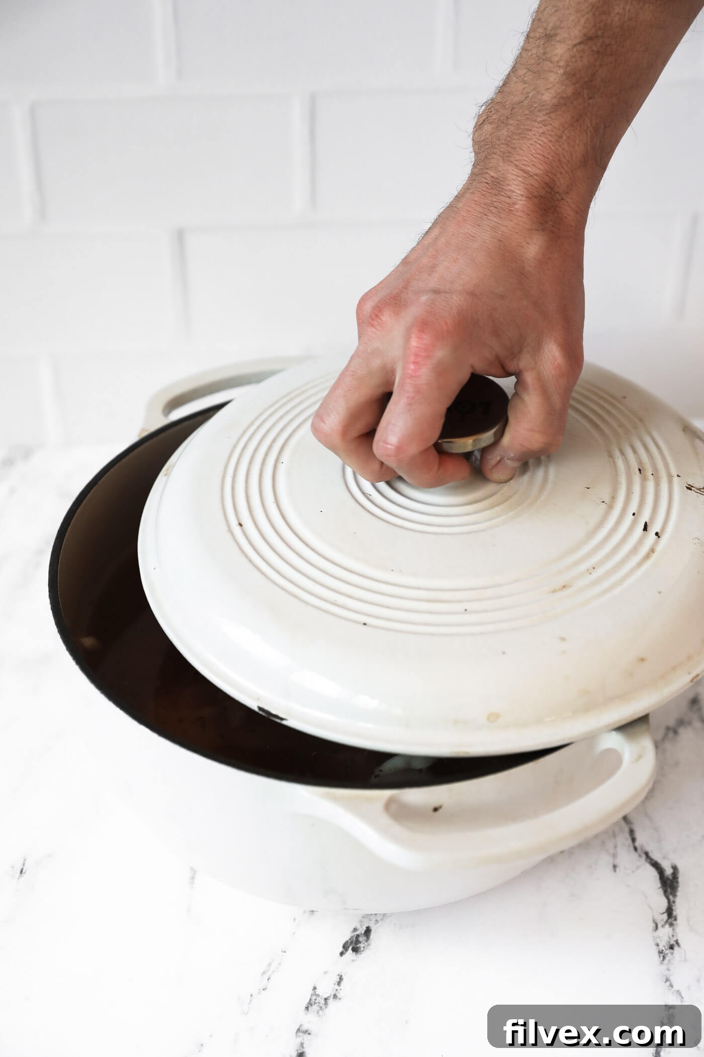 A Dutch oven, covered with its lid, simmering gently over medium-low heat to perfectly cook the chicken and infuse the broth with flavor.