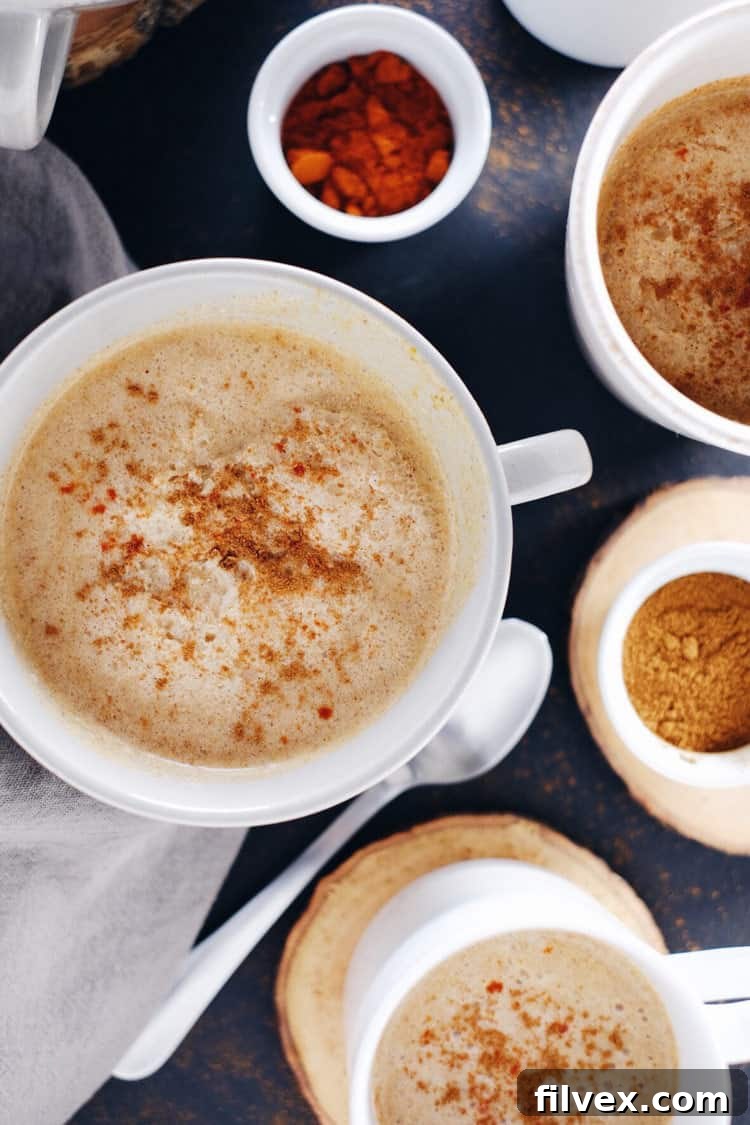 A close-up of Spiced Pumpkin Coconut Cider in a mug, garnished with cinnamon stick, embodying cozy fall vibes.