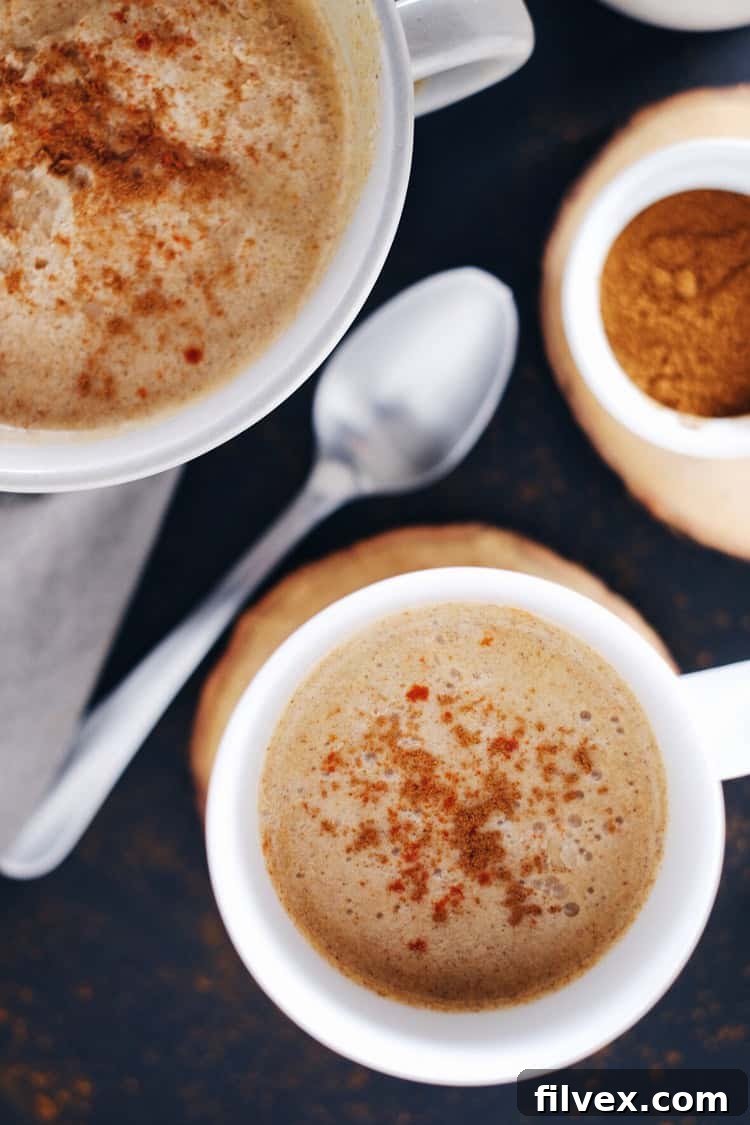 A mug of Spiced Pumpkin Coconut Cider, steam rising, conveying warmth and comfort in a rustic setting.