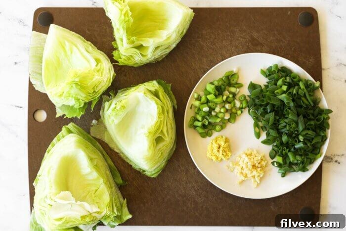 Overhead image of lettuce shells, chopped onions and grated ginger