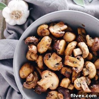A close-up shot of the finished garlic and sage brown butter mushrooms, glistening and ready to be served.