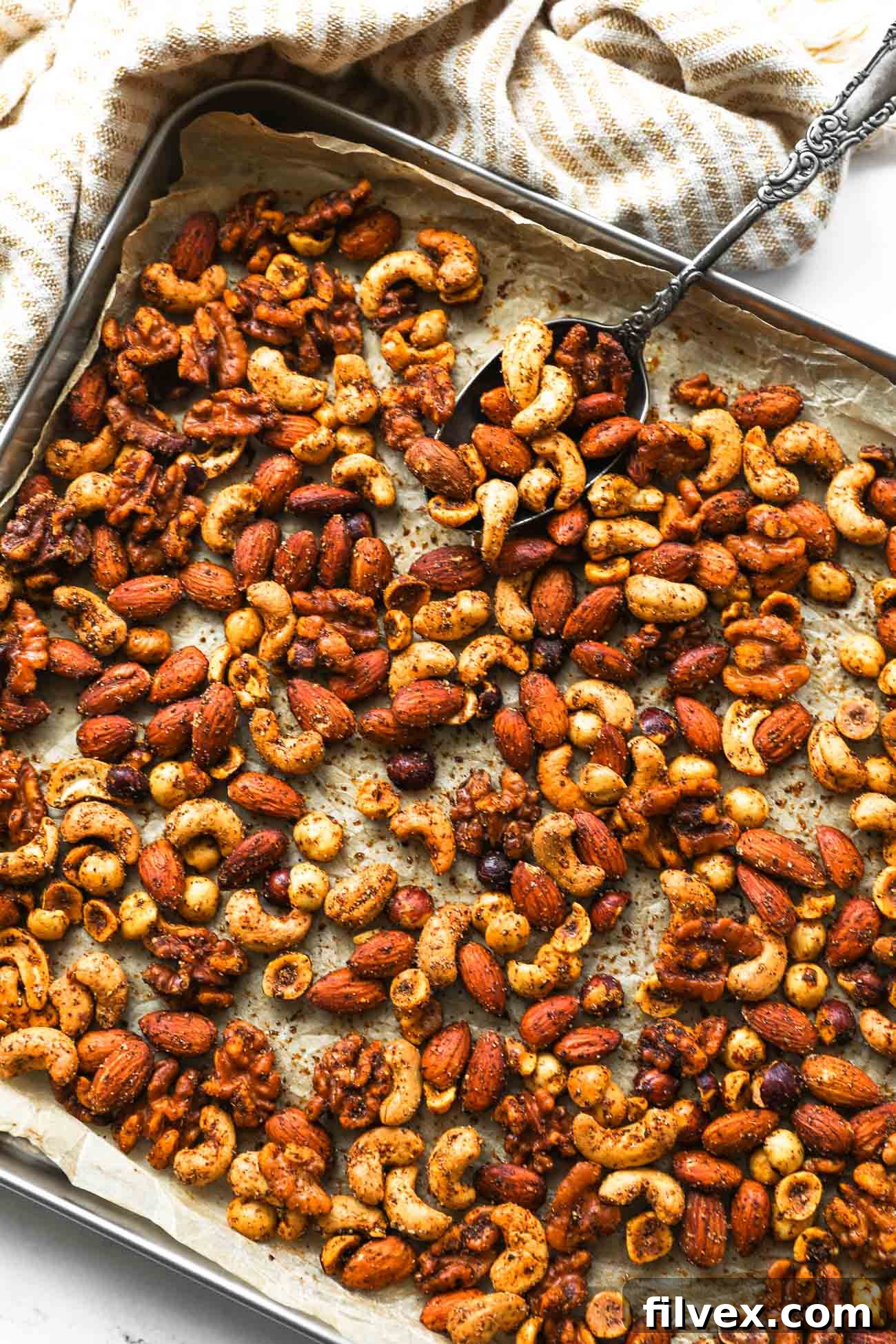 Delicious homemade spicy nut mix cooling on a baking sheet, ready to be enjoyed as a savory snack or appetizer.