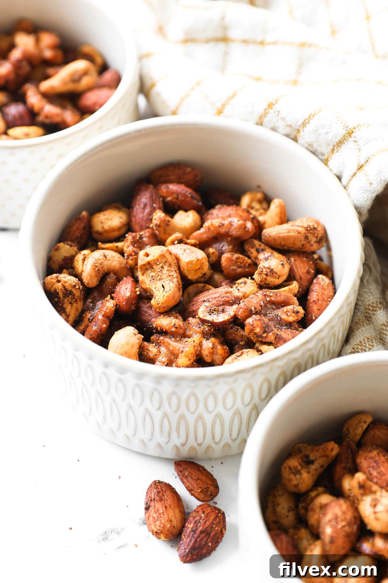 Close-up of a variety of roasted spicy nuts, highlighting their crispy texture and appealing seasoning, a perfect healthy snack.
