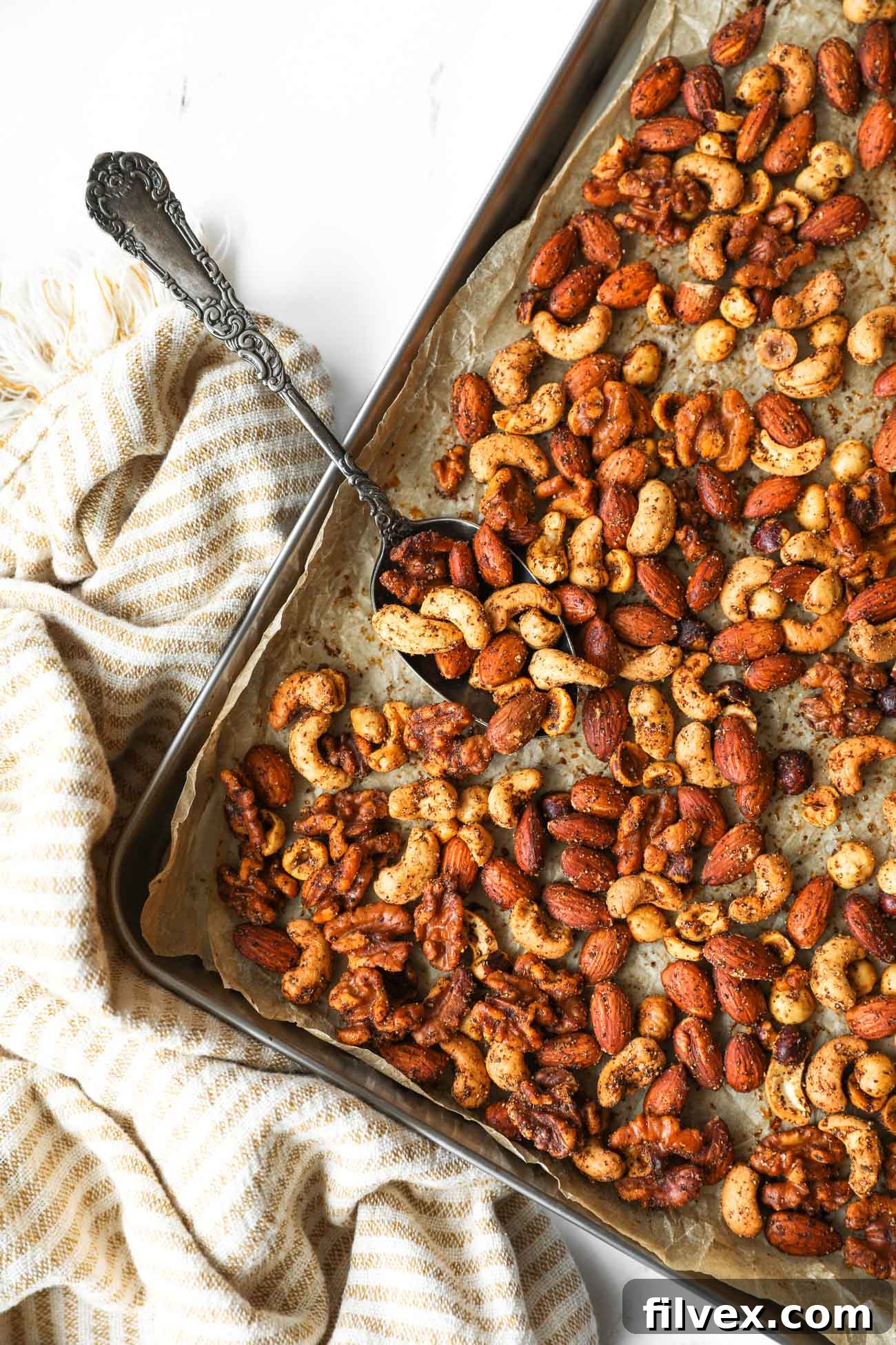 A mix of raw nuts and spices ready to be combined for a homemade snack, emphasizing the fresh ingredients.