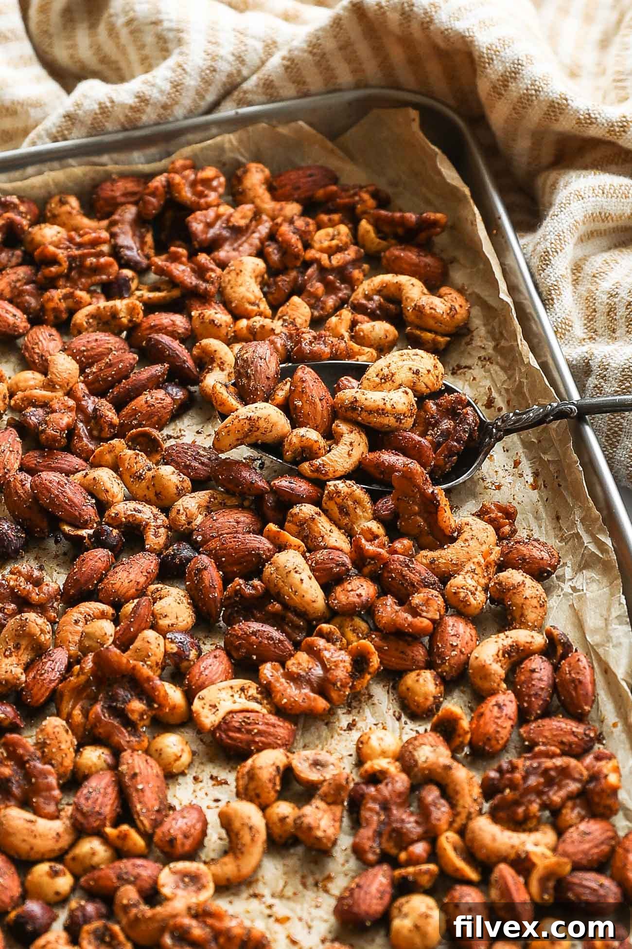 A beautiful bowl of homemade spicy nuts, ready for serving as a gourmet snack or appetizer, showcasing the rich seasoning.