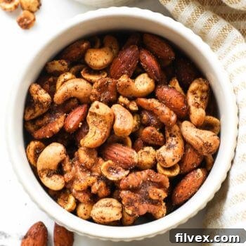 Overhead shot of ramekin full of homemade spicy nuts including walnuts, almonds, cashews and hazelnuts, visually appealing and ready to eat.