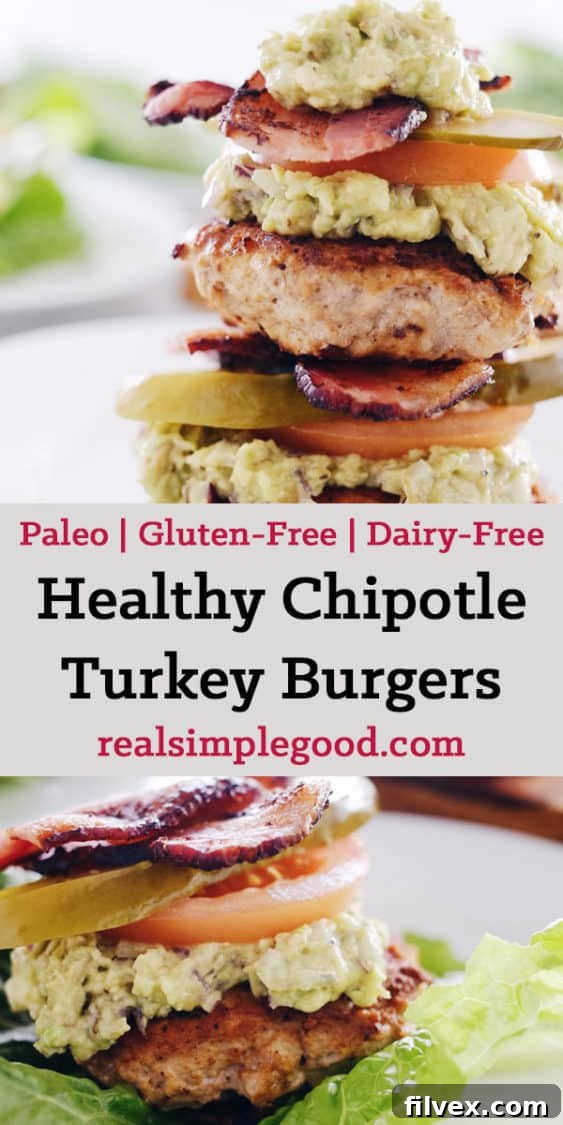 A stack of two juicy Chipotle Turkey Burgers in lettuce wraps, generously topped with guacamole, crispy bacon, and fresh tomato slices.