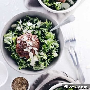 Three bowls of Caesar salads with burgers and parmesan cheese on top, ready to be served as a healthy and satisfying meal.