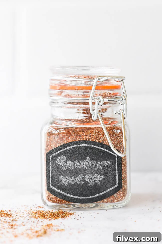 Southwest seasoning blend in a labeled glass jar, standing upright on a rustic surface.