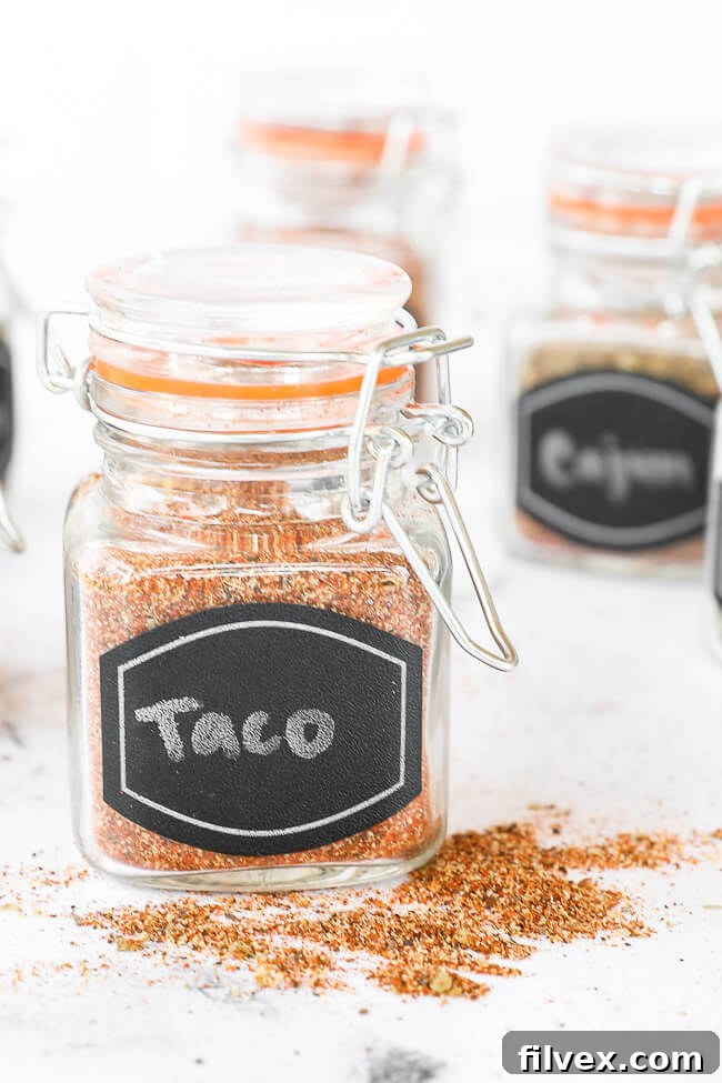 Taco seasoning blend stored in a clear glass jar with a handwritten label, positioned upright.
