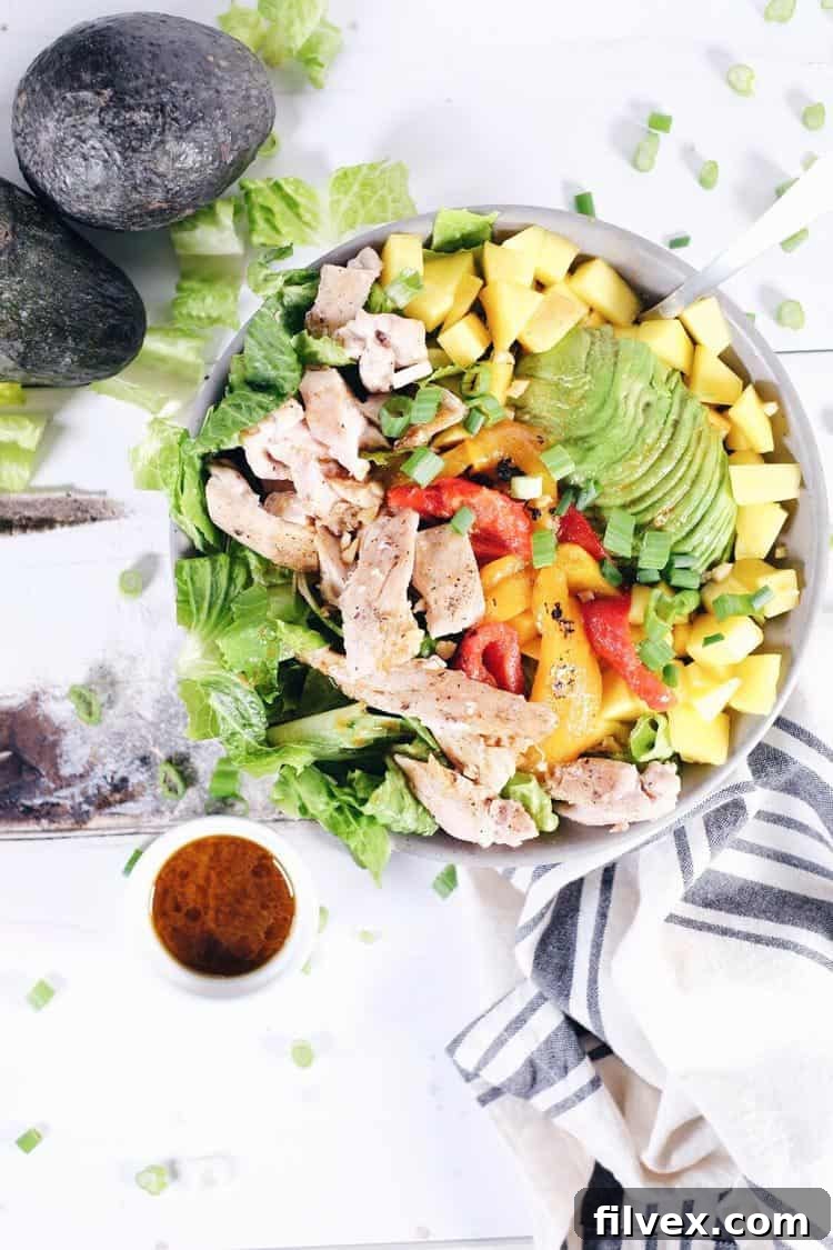 Pan-seared chicken thighs cooking, ready to be tossed in chili lime dressing for a healthy salad.